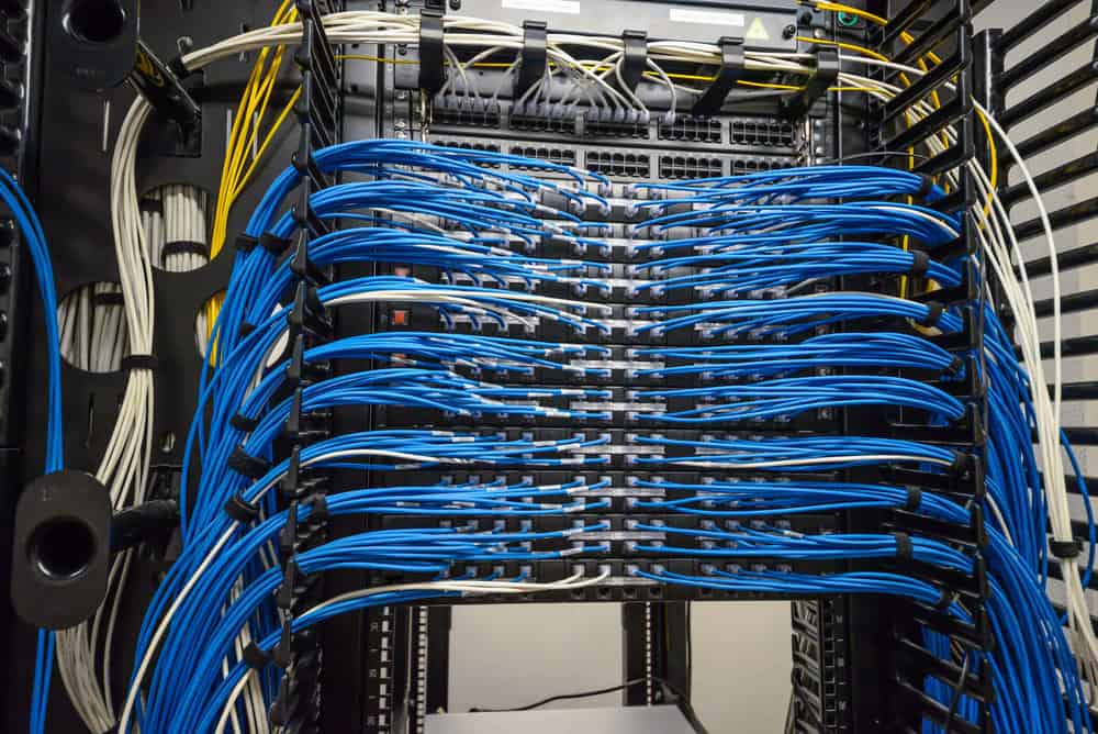 Commercial low-voltage network rack with organized blue patch cabling